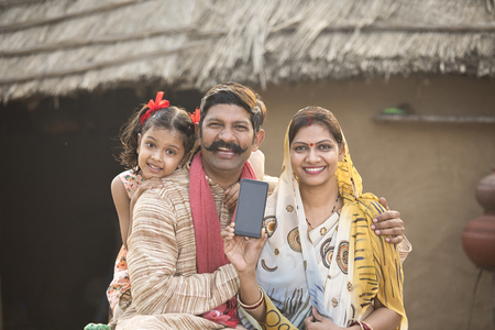 Delighted rural family holding new mobile phone