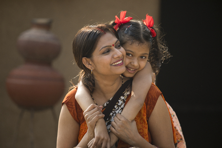 portrait of loving Indian mother and daughter at villageの写真素材
