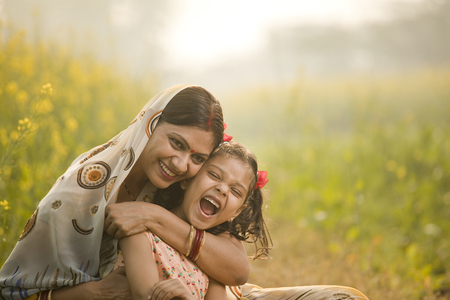 Mother with daughter having fun at agriculture fieldの写真素材