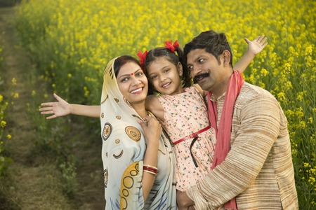 Rural happy Indian family in agricultural fieldの写真素材