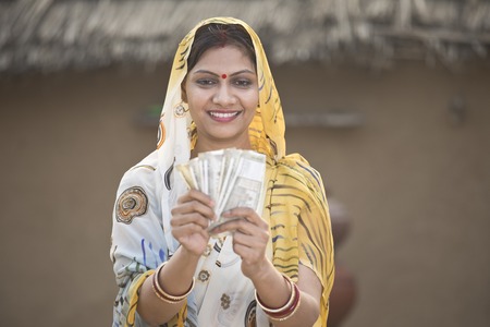 Excited woman holding Indian rupee notes and screaming