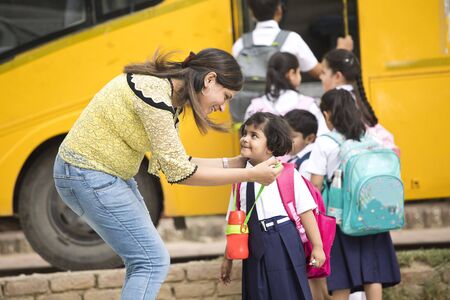 Teacher talking with student before they get on school bus