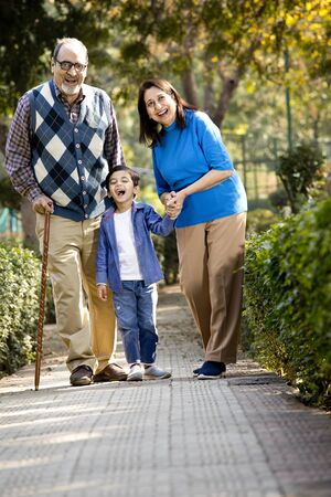 Happy grandparents spending leisure time with little grandson