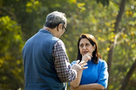 Senior couple discussing at parkの写真素材