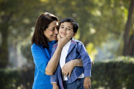 Woman embracing grandson at park