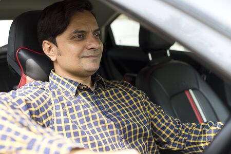 Young indian man driving car in cityの写真素材