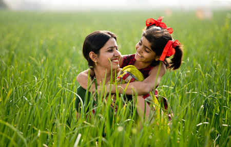 Happy mother and daughter at agricultural field
