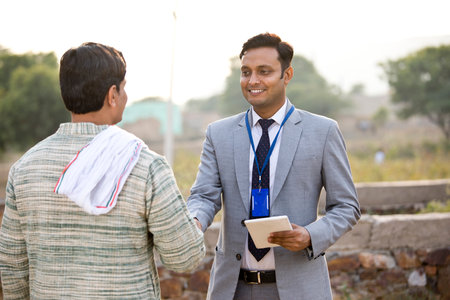 Farmer with businessman using digital tablet on agriculture fieldの写真素材