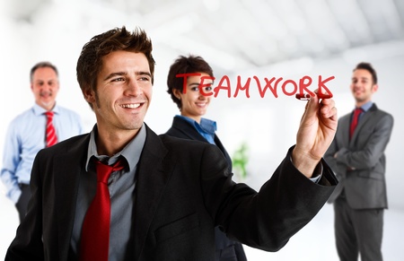 Friendly businessman writing the word Teamwork on the screenの写真素材