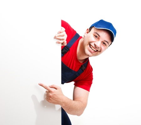 Portrait of a friendly worker pointing his finger to a blank boardの写真素材