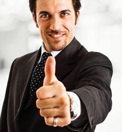 Handsome businessman showing thumb upの写真素材