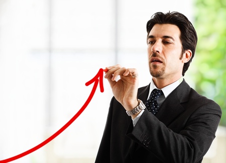 Businessman drawing a positive graphの写真素材