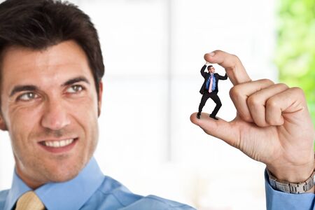 Little businessman getting crushed by a big bad oneの写真素材