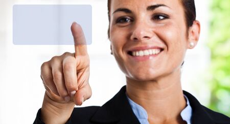 Portrait of a smiling businesswoman using a touch screenの写真素材