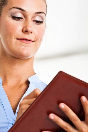 Portrait of a smiling woman writing on her agendaの写真素材