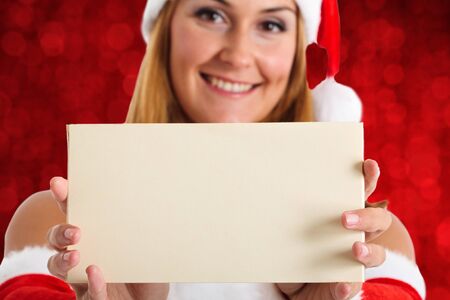 Beautiful Christmas girl showing a blank letterの写真素材