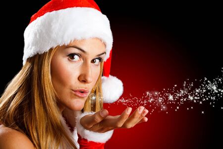 Portrait of a beautiful Christmas girl blowing starsの写真素材
