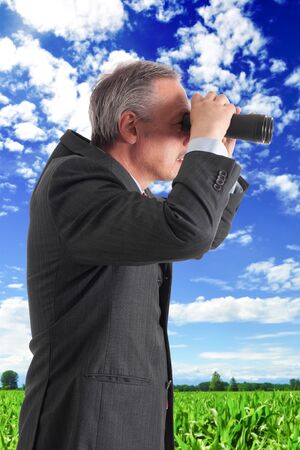 Manager searching for new opportunities using binocularsの写真素材