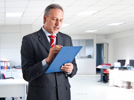 Portrait of a senior businessman reading a documentの写真素材