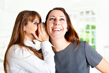 Girl telling funny news to her friend