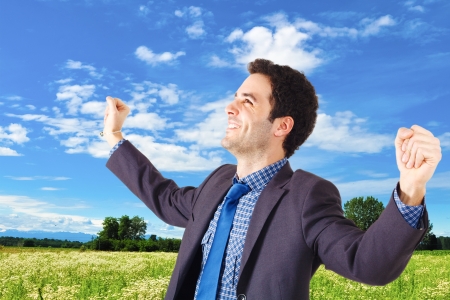 Young businessman raising his hands in sign of victoryの写真素材