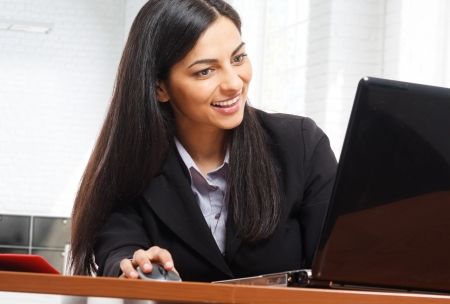 Portrait of a smiling woman using a laptopの写真素材