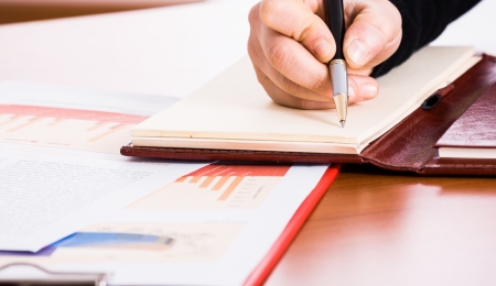 Business person writing on a notebookの写真素材