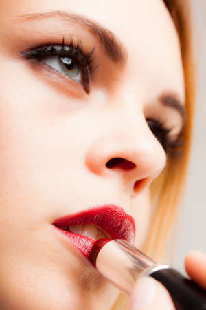 Portrait of a gorgeous woman applying lipstickの写真素材