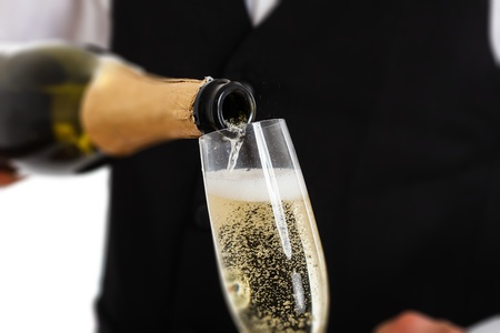 Portrait of a waiter pouring champagne into a fluteの写真素材