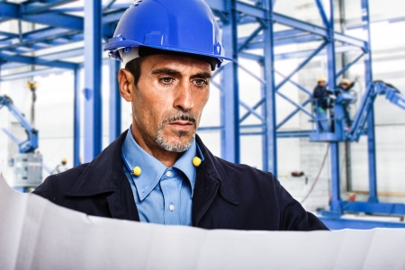 Portrait of an engineer reading a blueprintの写真素材
