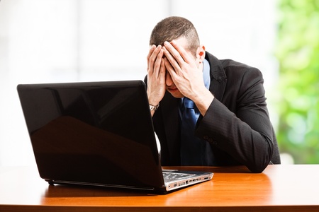 Portrait of a stressed businessman lying on the deskの写真素材