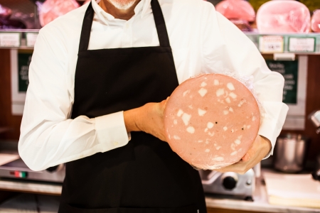 Shopkeeper showing bologna in an italian grocery storeの写真素材