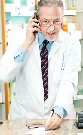Portrait of a pharmacist at work in his shopの写真素材