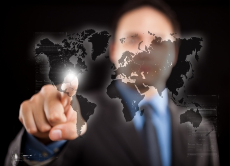 Man pointing his finger on a digital world mapの写真素材