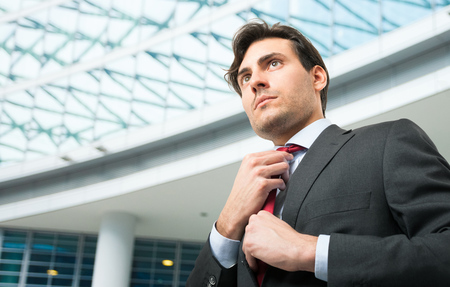 Portrait of a businessman adjusting his tieの写真素材