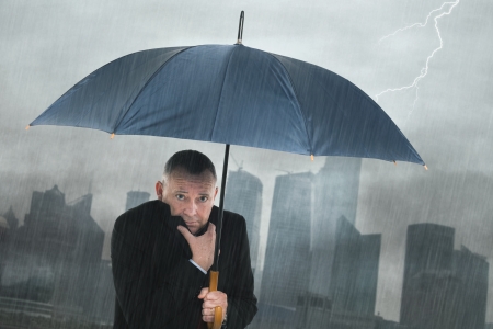Portrait of depressed businessman under the rainの写真素材