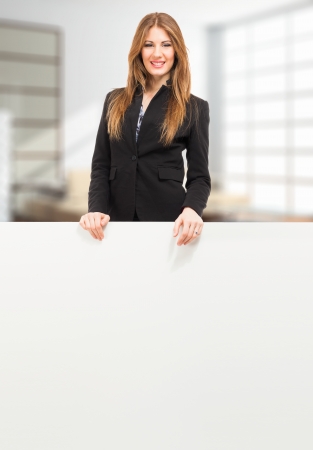 Beautiful woman showing a white boardの写真素材