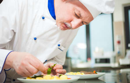 Professional chef garnishing a dishの写真素材