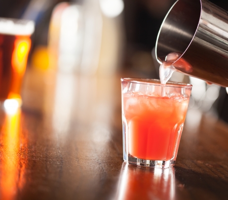 Bartender serving a cocktail from a shakerの写真素材