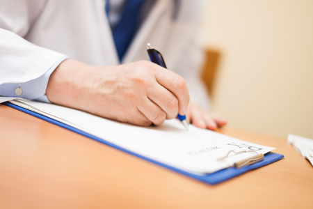 Detail of a doctor writing a prescription