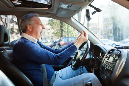 Portrait of an angry driver yelling in his car