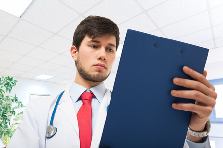 Portrait of a young doctor reading a clipboardの写真素材
