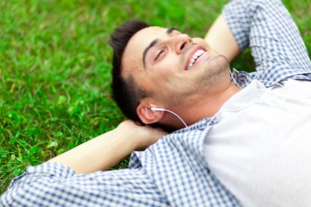 Young man relaxing on the grass in a parkの写真素材