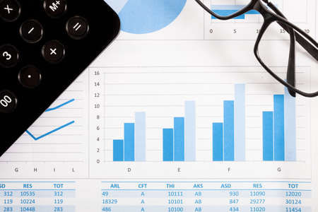 Eyeglasses and calculator over a business documentの写真素材
