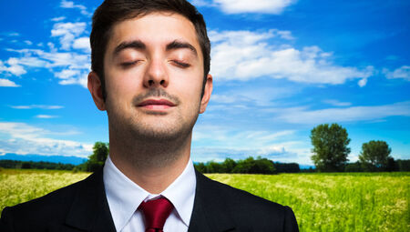 Ecology concept, portrait of a businessman relaxing in the countryの写真素材