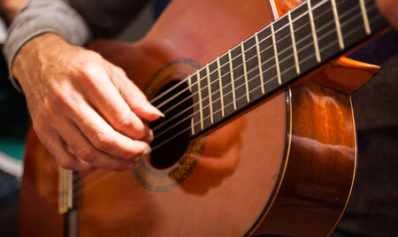 Detail of a man playing a guitar