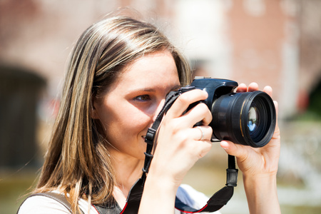Portrait of a female photographer using a cameraの写真素材