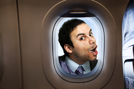Businessman looking  through an airplane windowの写真素材