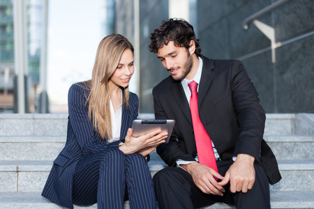 Business partners examining data on a digital tabletの写真素材