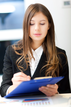 Smiling businesswoman writing in her officeの写真素材